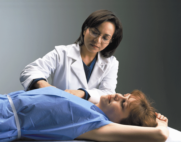 A doctor performing a breast exam on a woman.